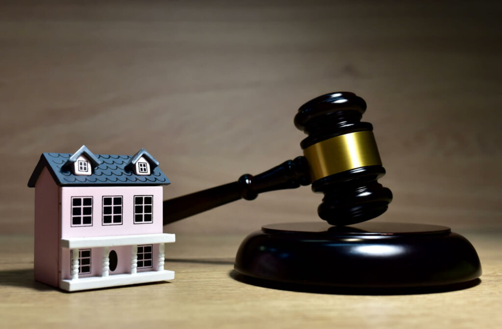 A miniature house and a gavel. The Dower Act is a piece of legislation that provides certain protections to spouses in real estate transactions in Canada