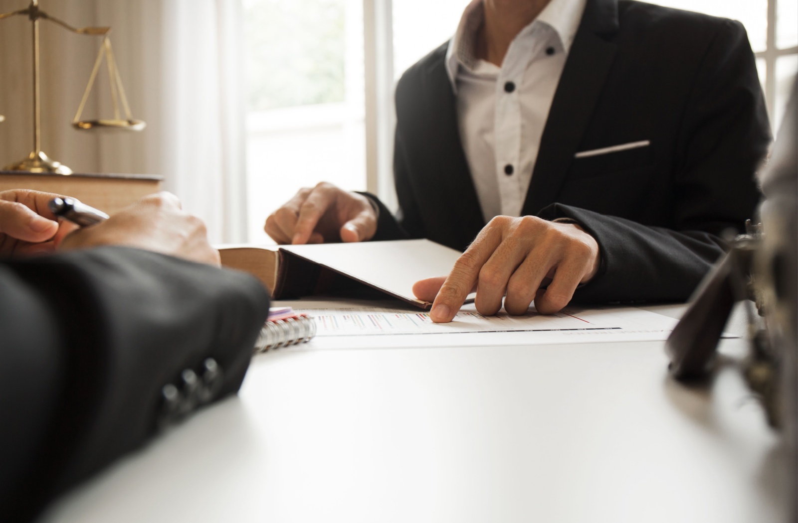 A lawyer pointing to documents while discussing with a client