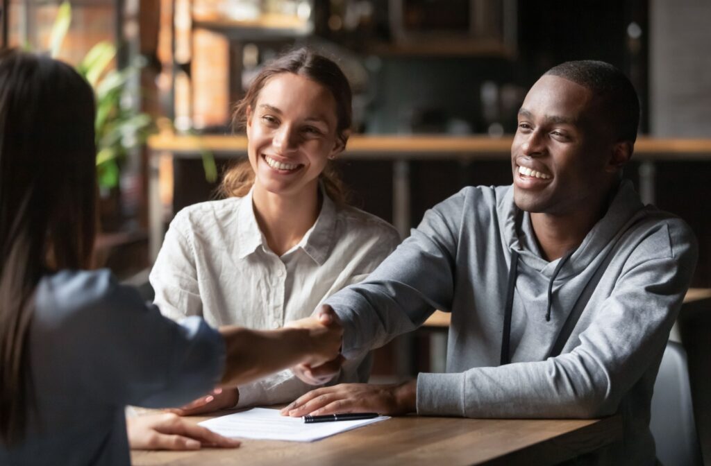 Two people shake hands with their corporate lawyer after discussing incorporation.