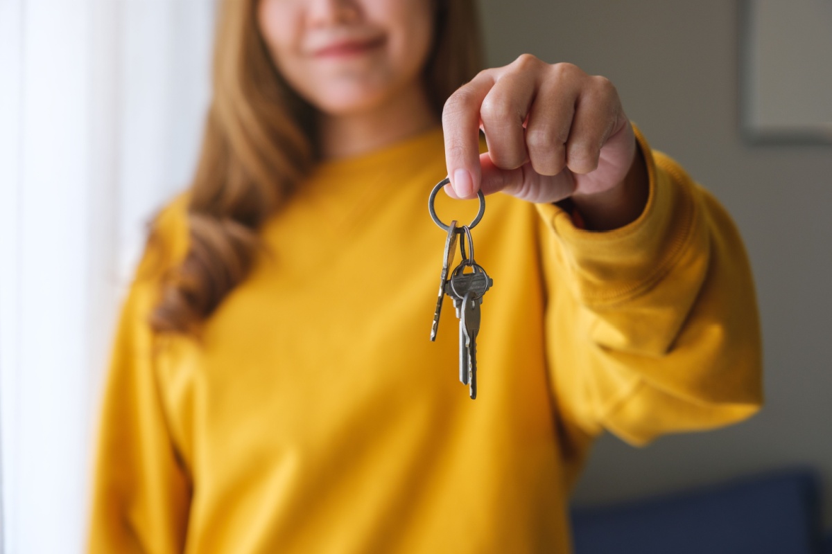 A person holding on to a set of keys to their new house